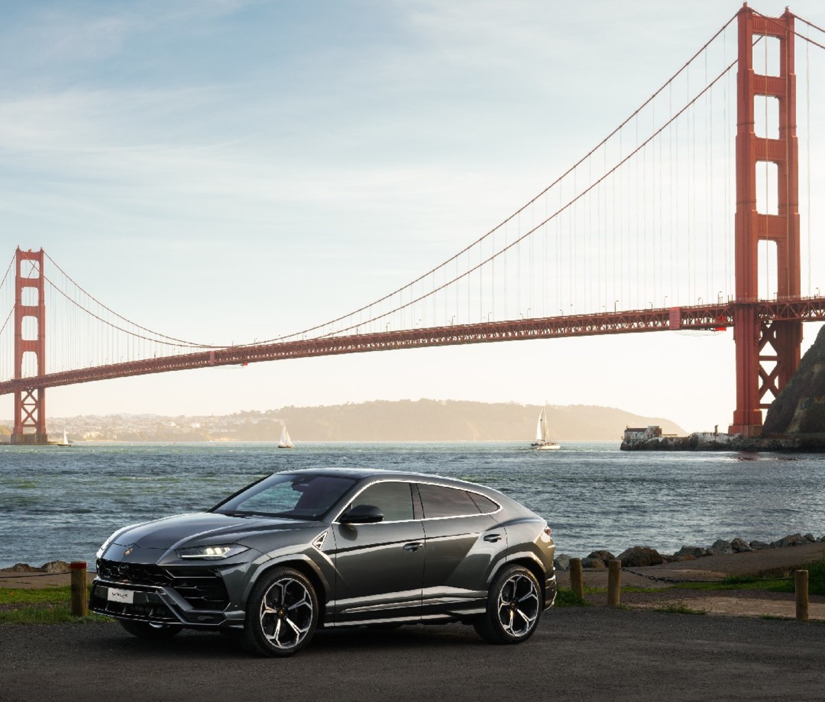 Black 2021 Lamborghini Urus parked by San Francisco Bay with Golden Gate Bridge in the background