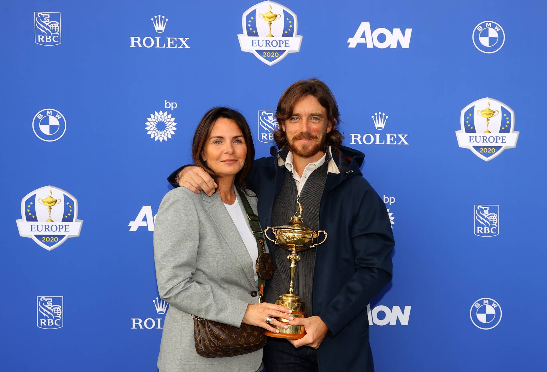 Tommy Fleetwood of Team Europe and wife Clare Fleetwood pose with the Ryder Cup Trophy.