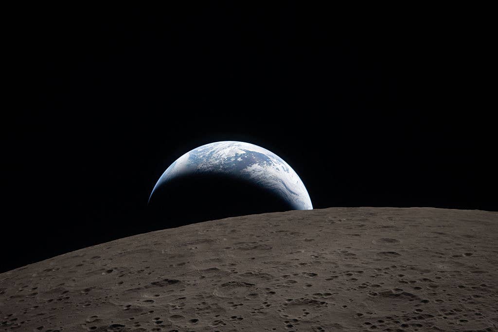 IN SPACE – APRIL 06: (EDITOR’S NOTE: This Handout image was provided by a third-party organization and may not adhere to Getty Images’ editorial policy.) In this handout image provided by NASA, Earthset captured through the Orion spacecraft window at 6:41 p.m. EDT, April 6, 2026, during the Artemis II crew’s flyby of the Moon. A muted blue Earth with bright white clouds sets behind the cratered lunar surface. The dark portion of Earth is experiencing nighttime. On Earth’s day side, swirling clouds are visible over the Australia and Oceania region. In the foreground, Ohm crater has terraced edges and a flat floor interrupted by central peaks. Central peaks form in complex craters when the lunar surface, liquefied on impact, splashes upwards during the crater’s formation. (Photo by NASA via Getty Images) 