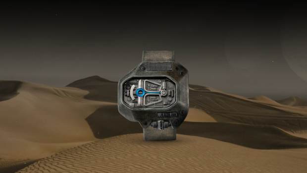 Sci-fi watch made for the movie Dune: Part Two floating in the air with a desert landscape with dunes in the background.