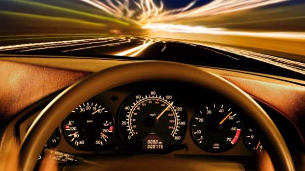 Stock photo of the dashboard of car going over 100 mph.