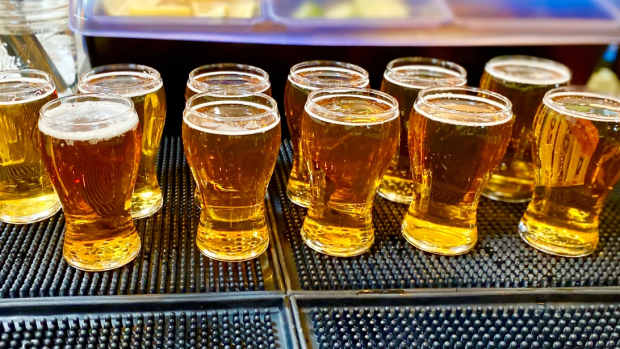 Stock photo of flights of beer glasses lined up at a bar.