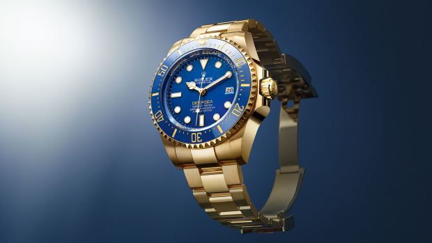 Oyster Perpetual Rolex Deepsea 44mm, with blue lacquer dial and yellow gold band, on royal blue background with white radial light