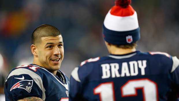 Tom Brady #12 of the New England Patriots chats with Aaron Hernandez #81 against the Houston Texans at Gillette Stadium on December 10, 2012 in Foxboro, Massachusetts.