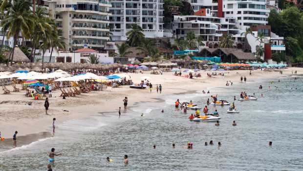 People enjoy the beach in the resort city of Puerto Vallarta in the western Mexican state of Jalisco, on August 18, 2016. 
Jesus Alfredo Guzman Salazar, the son of drug lord Joaquin "El Chapo" Guzman, was among a group kidnapped August 15 from an upscale bar in Puerto Vallarta, authorities confirmed.  / AFP / HECTOR GUERRERO        (Photo credit should read HECTOR GUERRERO/AFP via Getty Images)
