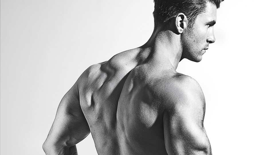 Black-and-white photo of shirtless caucasian man with muscular back