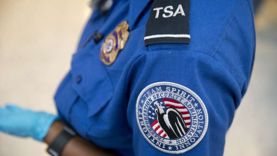 A Transportation Security Administration (TSA) officer stands in the TSA pre-check area at Dulles International Airport in Dulles, Virginia, U.S., on Wednesday, Aug. 19, 2015. The TSA, part of the Homeland Security Department (DHS), reported seizing a record number of firearms at U.S. airports in 2015, a 20 precent increase over 2014.Photographer: Andrew Harrer/Bloomberg via Getty Images