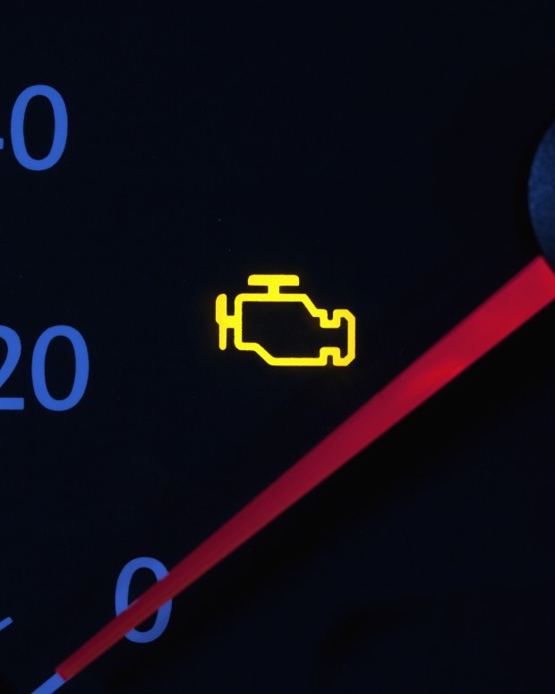 Yellow engine check engine icon on car dashboard.