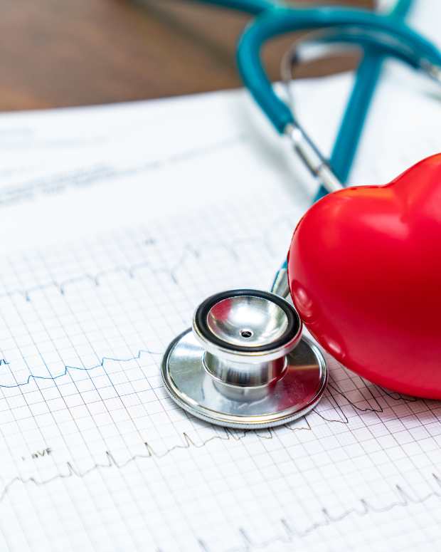 Stethoscope and red heart on electrocardiogram.