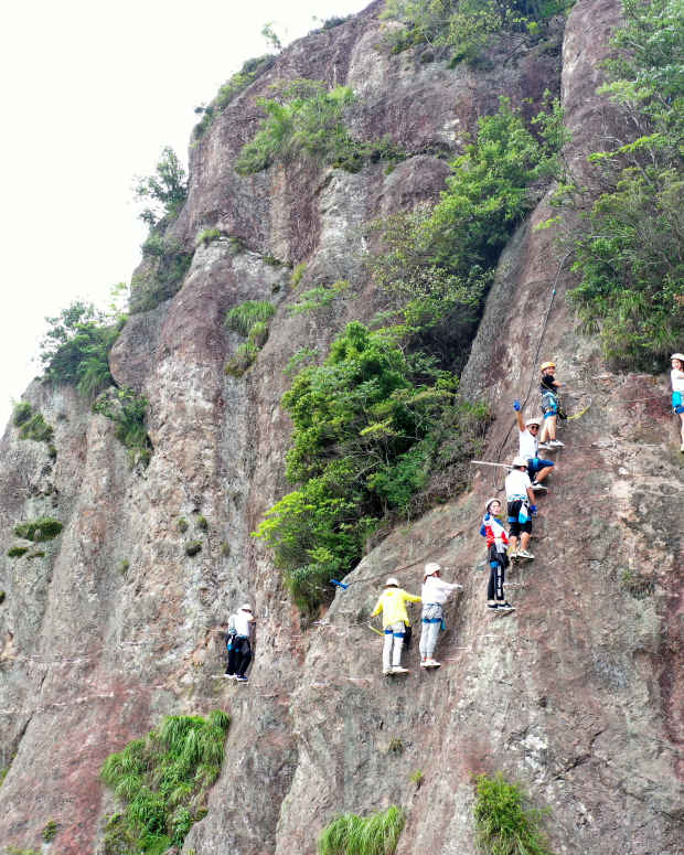 Tourists challenge themselves on a 'Via Ferrata' route, or protected climbing route, at Yandang Mountain on May 30, 2021 in Leqing, Zhejiang Province of China.