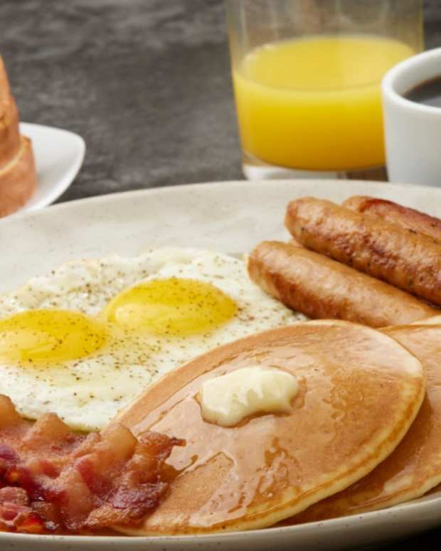 Stock photo of a breakfast plate with pancakes, bacon, eggs, and toast.