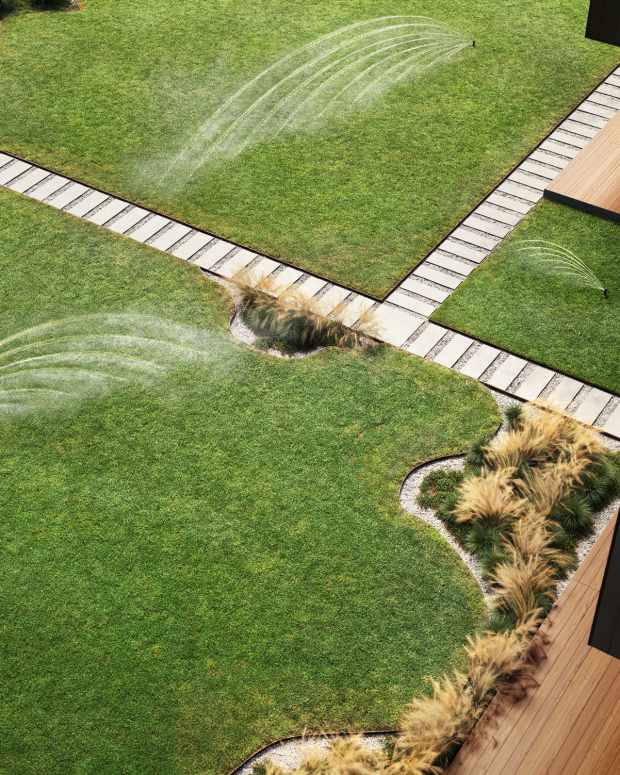 An overhead view of a yard with irrigation systems watering the lawn.