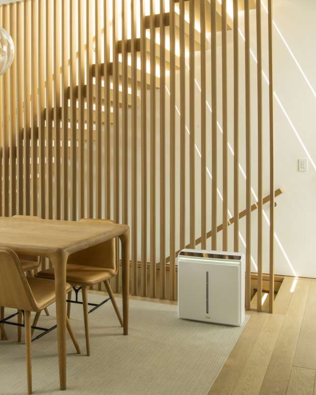 Air purifier sits near a staircase in a midcentury dining room.