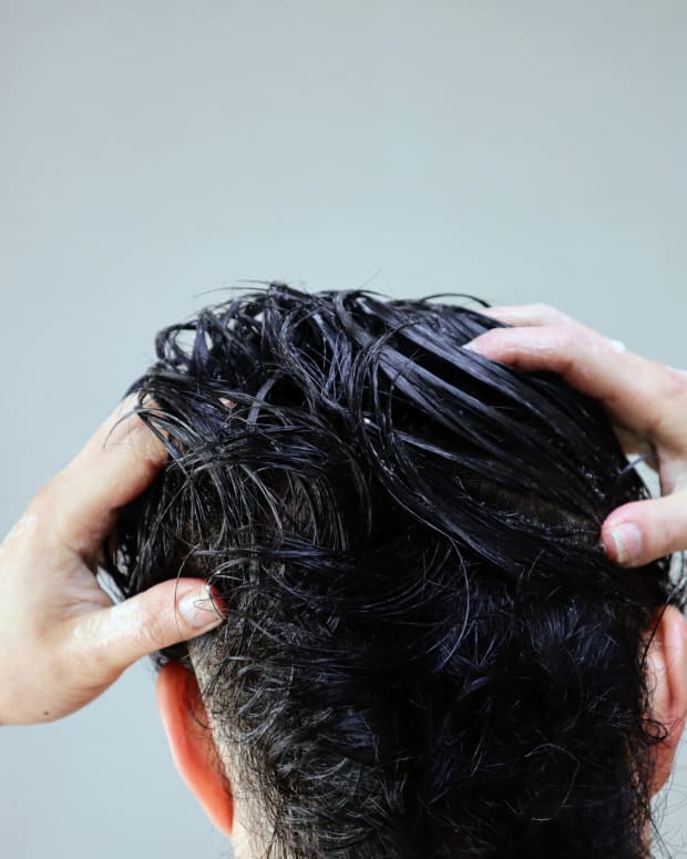 man putting product in hair