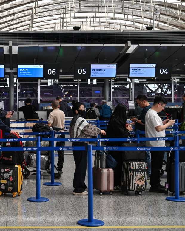 Passengers wait at the counter of American Airlines for their flight at the Shanghai Pudong International Airport in Shanghai on April 17, 2025.