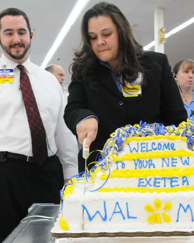 Photo by Tim Leedy 10/14/09Exeter Wal-Mart grand reopening.James Wood, overnight shift amanger (L) watches as Store shift manager Jodi Whyte cuts the cake for the grand reopening. (Photo By Reading Eagle: Tim Leedy/MediaNews Group/Reading Eagle via Getty Images)