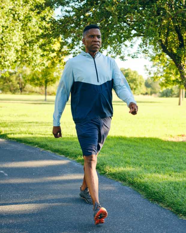 A mature black man, exercising in a park in the morning.