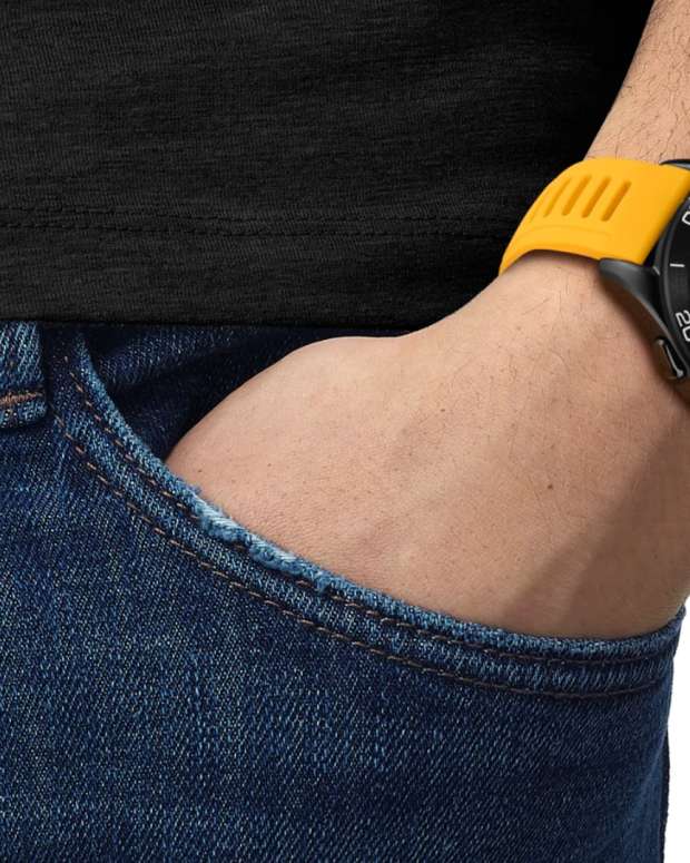 Man in jeans wearing a black and yellow Tissot T-Touch Connect Sport Jungfraubahn, new watch release.