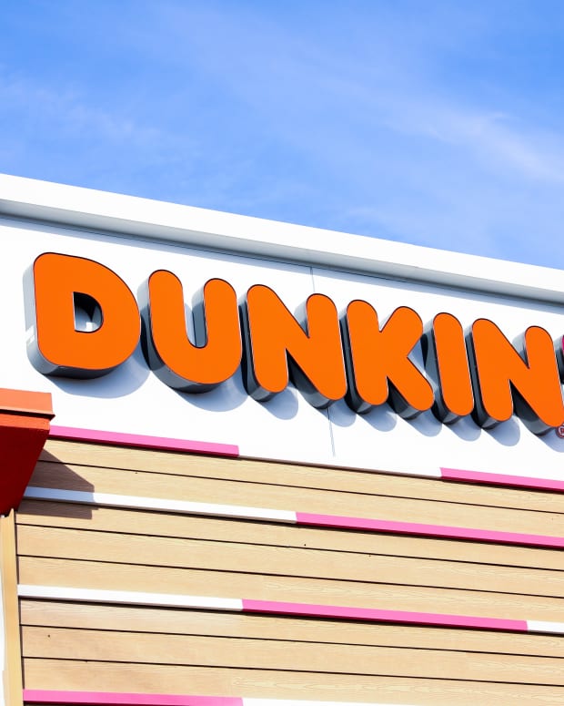 Chicago, IL, USA, December 3, 2023, Dunkin' Donuts sign illuminating a stack of branded boxes, inviting and delicious treats on display