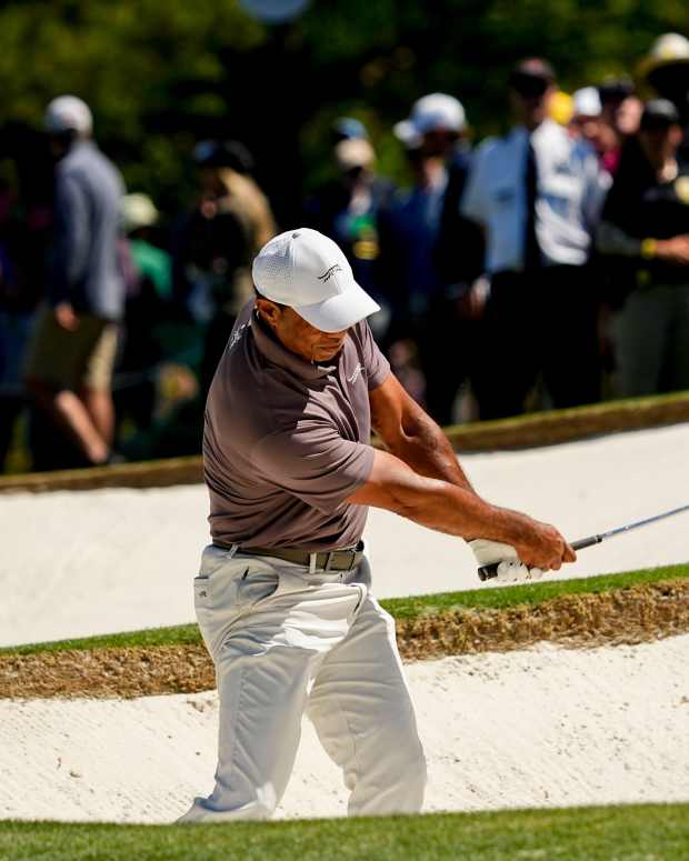 Apr 12, 2024; Augusta, Georgia, USA; Tiger Woods hits out of a bunker onto the no. 7 green during the second round of the Masters Tournament.