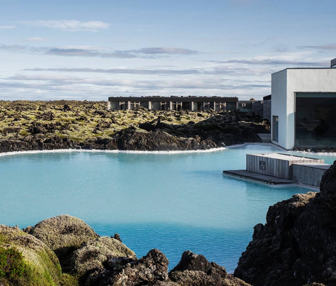 The Blue Lagoon in Iceland with a white building nearby. hotel pools