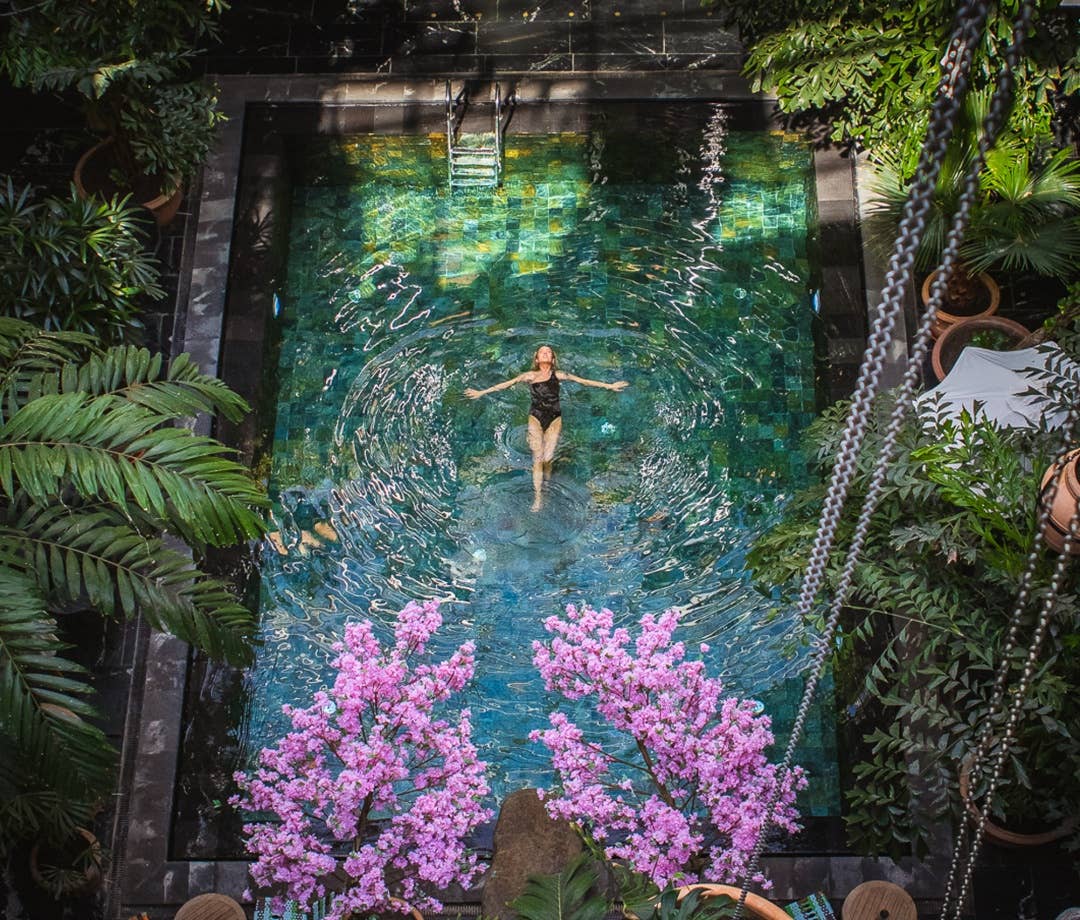 Woman swimming on her back in the Manon les Suites hotel pool. hotel pools