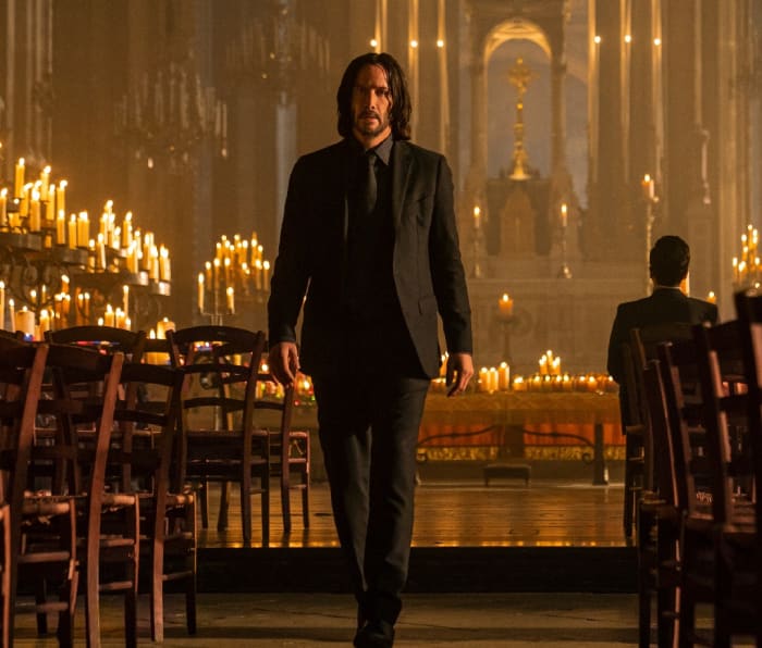 Keanu Reeves walks through a cathedral in a scene from John Wick: Chapter 4