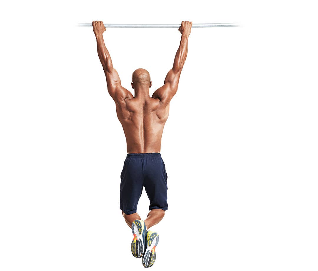 Best Lat Exercises: A shirtless black man in navy shorts performs pullup.
