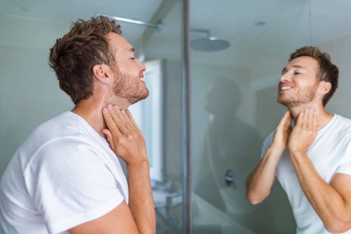 Man doing morning skincare regimen in bathroom