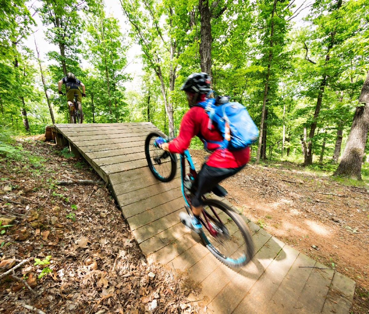 Mountain biker heading up a woodsy trail in Bentonville, AR.