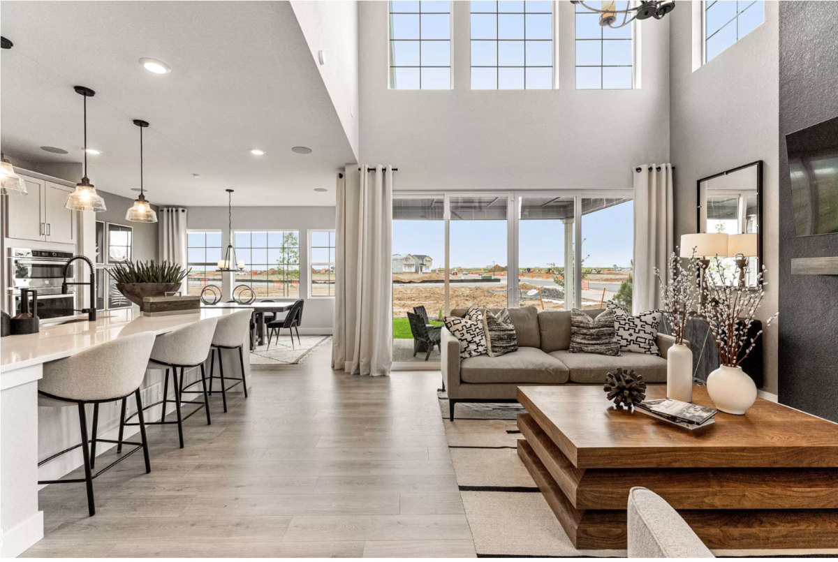 An open concept kitchen, dining room, and living room with a two-story ceiling breathes quiet luxury.