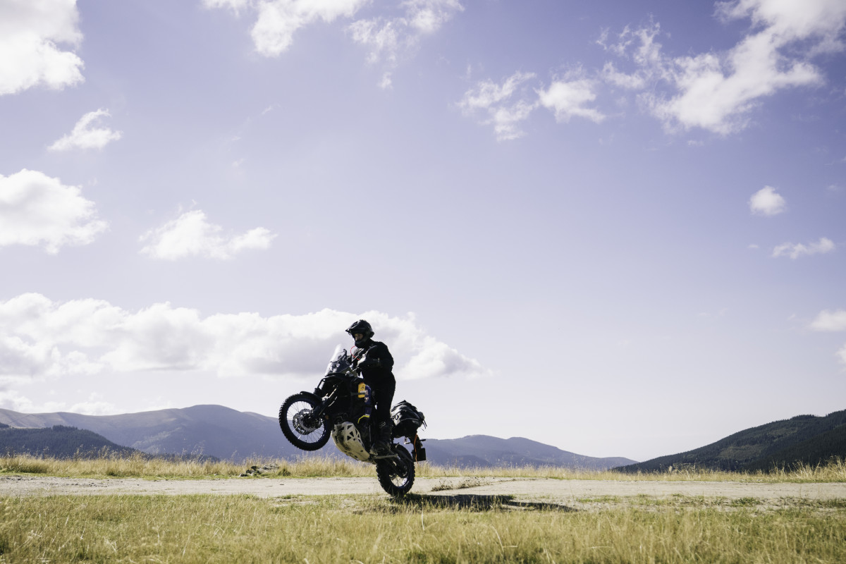 Popping wheelie on motorbike in Turkey grasslands