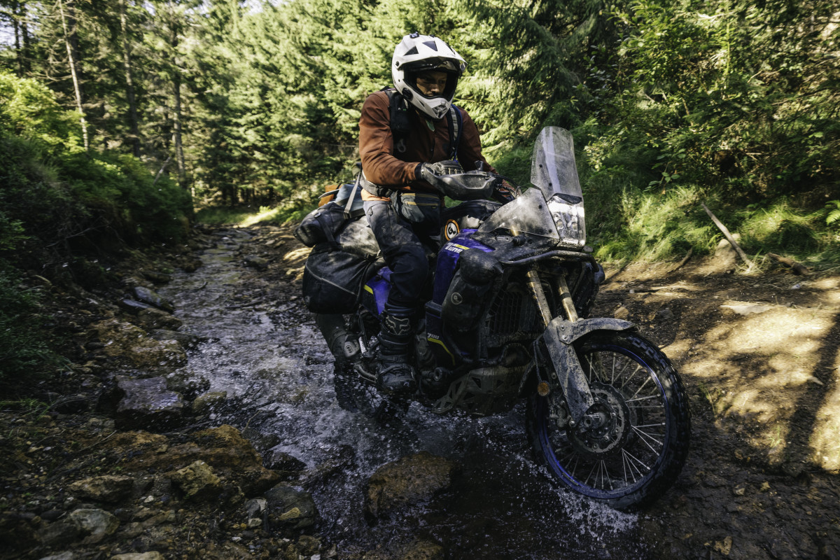 Riding motobikes through technical terrain and a stream along Silk Road