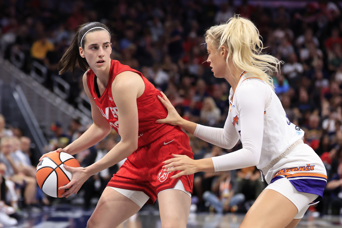INDIANAPOLIS, INDIANA - AUGUST 16: Caitlin Clark #22 of the Indiana Fever makes a move on Sophie Cunningham #9 of the Phoenix Mercury at Gainbridge Fieldhouse on August 16, 2024 in Indianapolis, Indiana. NOTE TO USER: User expressly acknowledges and agrees that, by downloading and or using this photograph, User is consenting to the terms and conditions of the Getty Images License Agreement. (Photo by Justin Casterline/Getty Images)