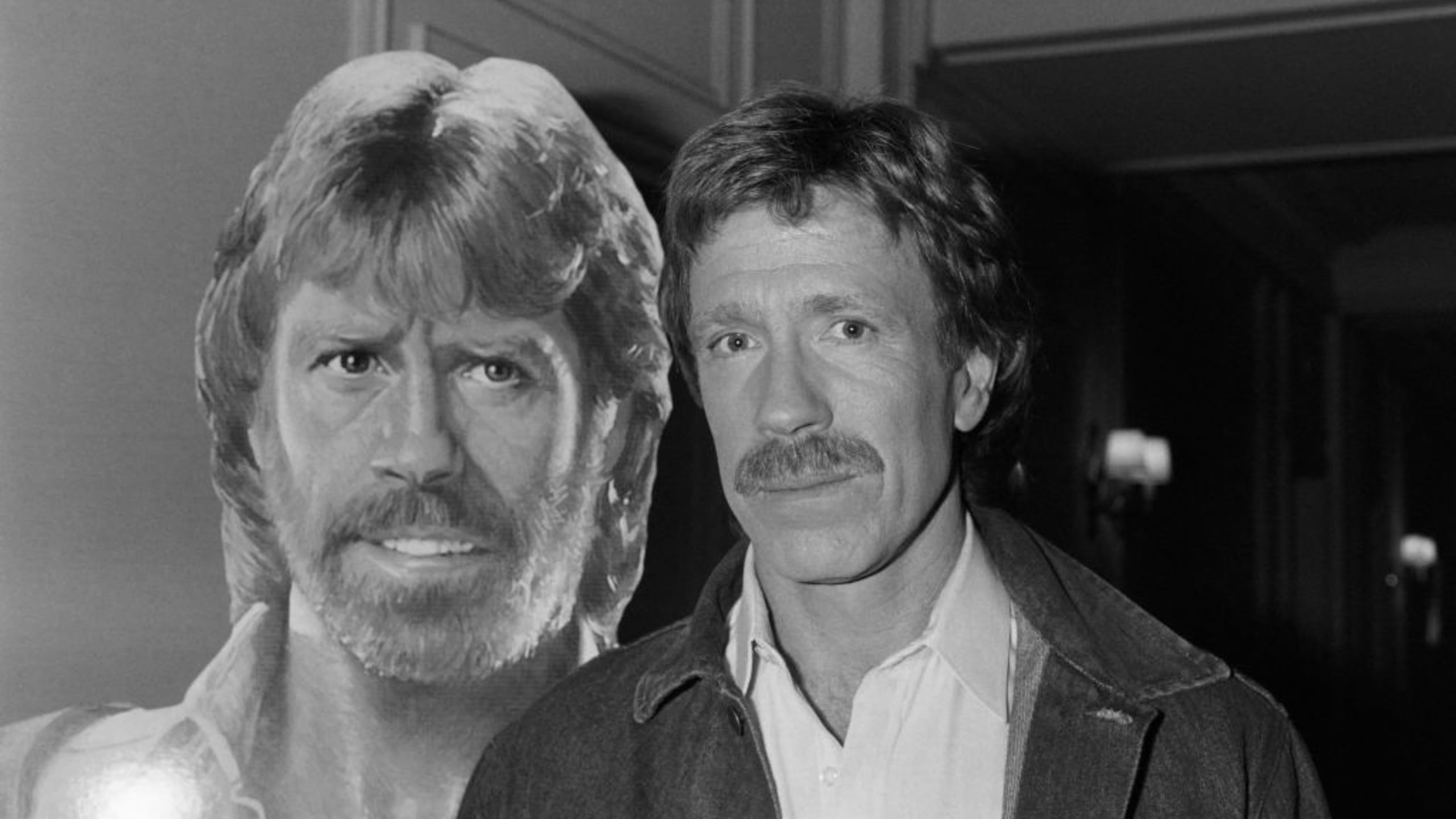 US actor Chuck Norris poses on November 27, 1985 in front of the poster for the movie “Invasion USA” at the Hôtel Plaza Athénée in Paris. (Photo by Pierre VERDY / AFP) 

