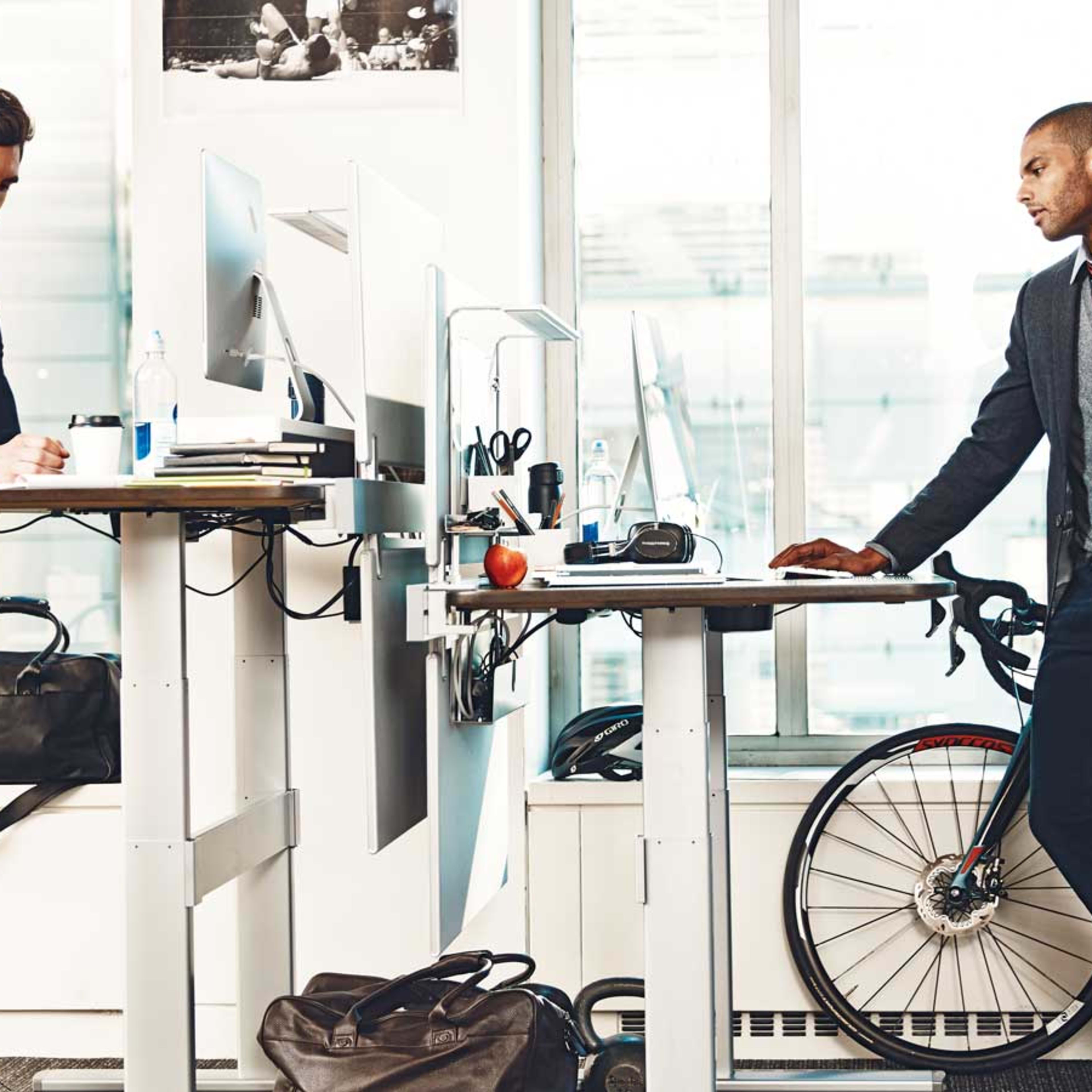 Young men at standing desks in office
