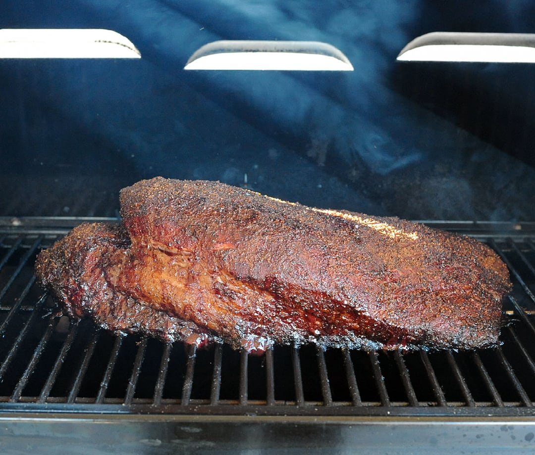 A beef brisket smoking on a pellet grill.