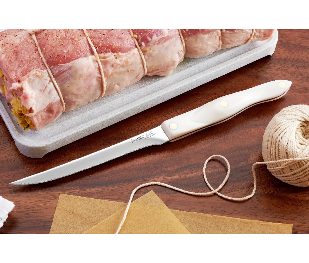 Cutco Boning Knife with pork loin and cooking twine on a wooden table.