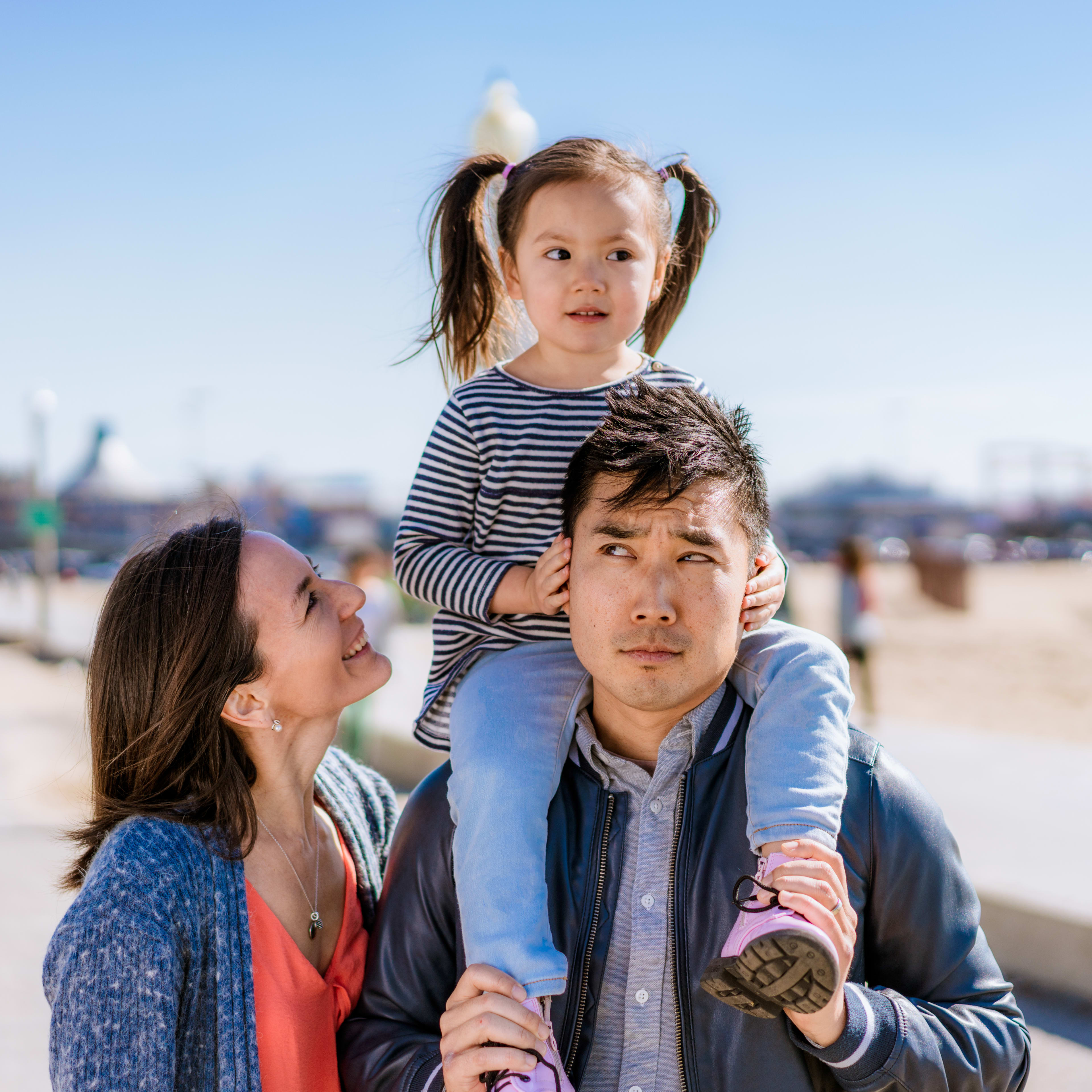 A girl trying to decide which way to direct her Dad, as her mother looks on.