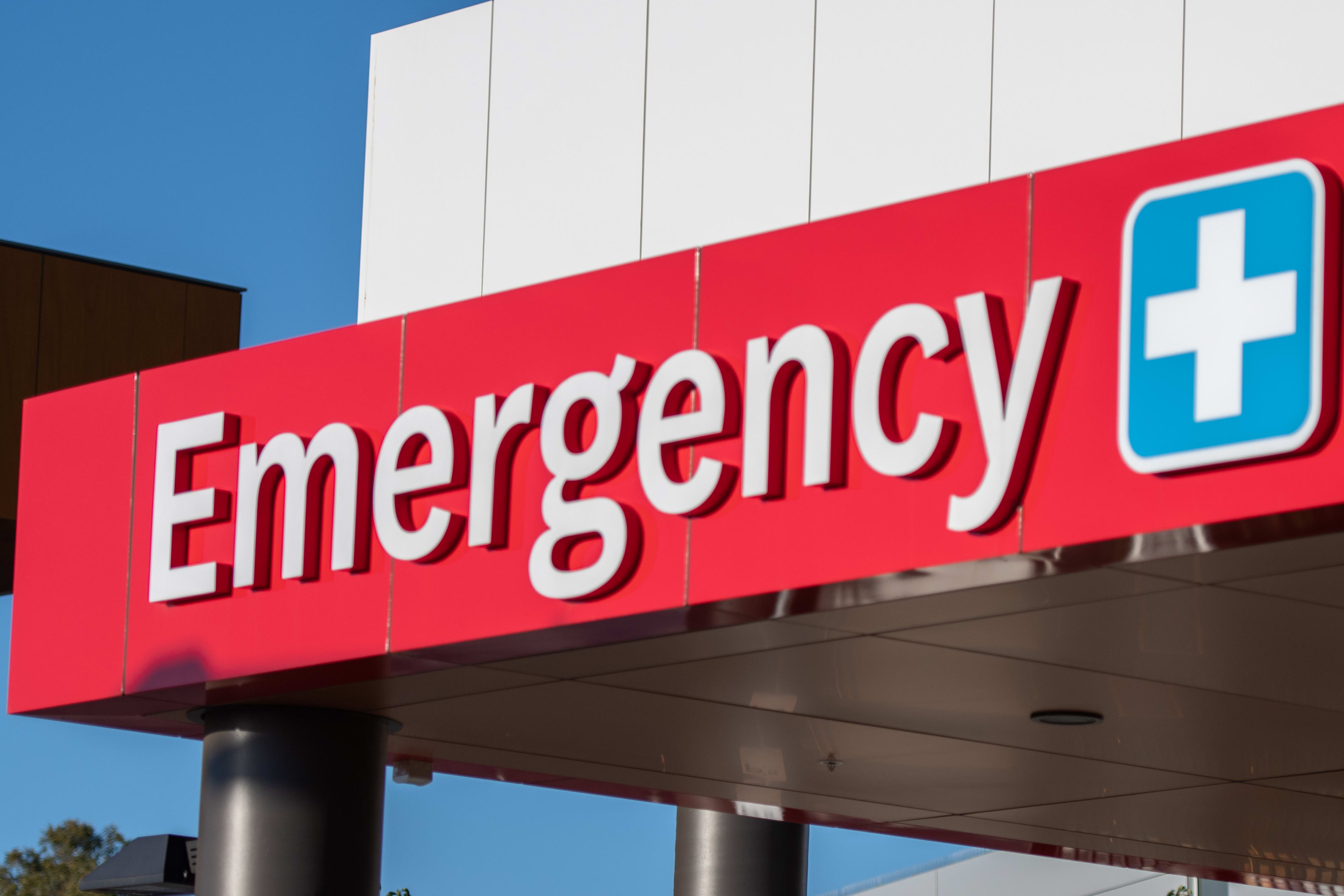 Emergency department sign at the top of a hospital.