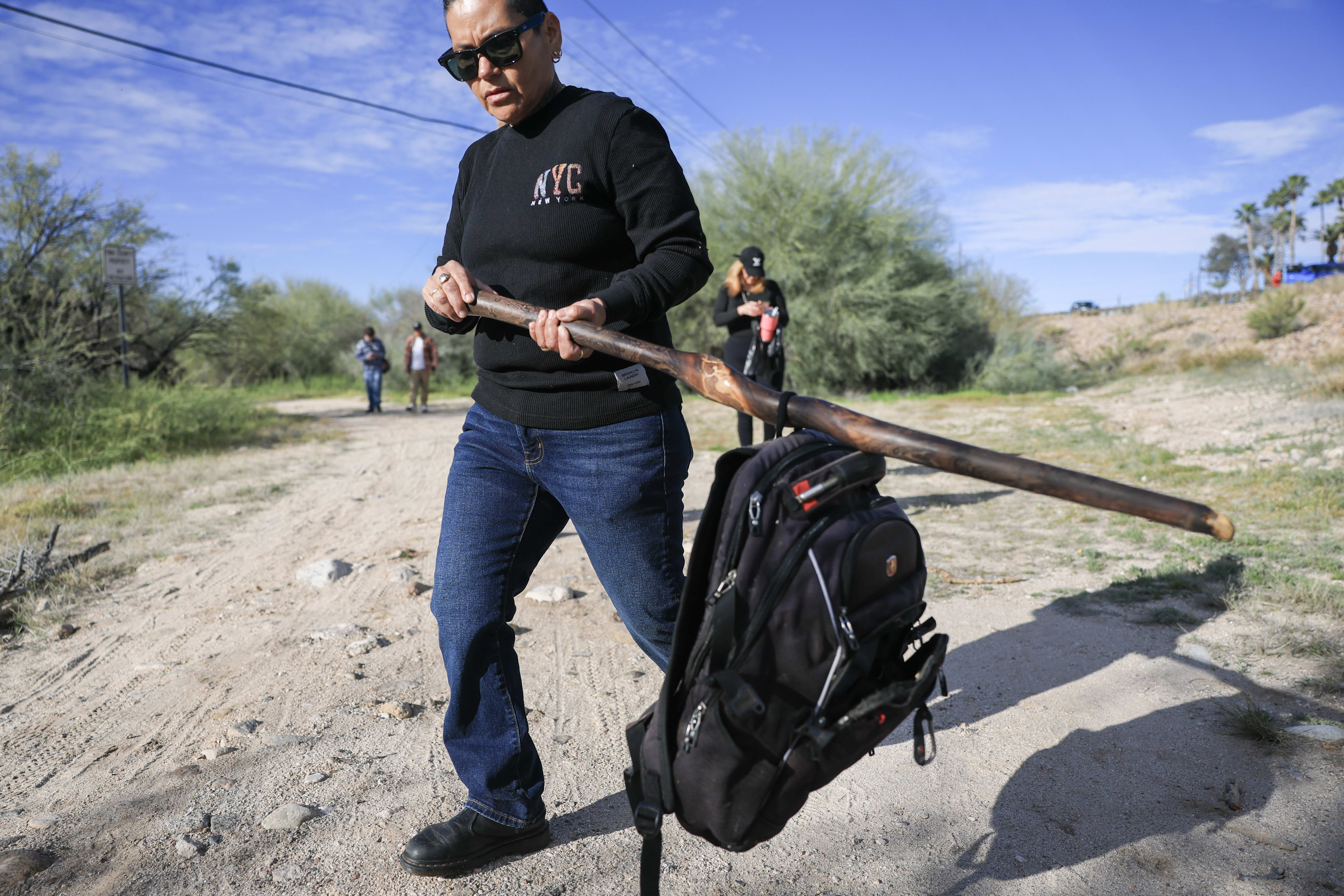 Catherine Lopez holds black backpack discovered by volunteers in Tucson culvert while searching for clues in Nancy Guthrie disappearance case, February 22, 2026.