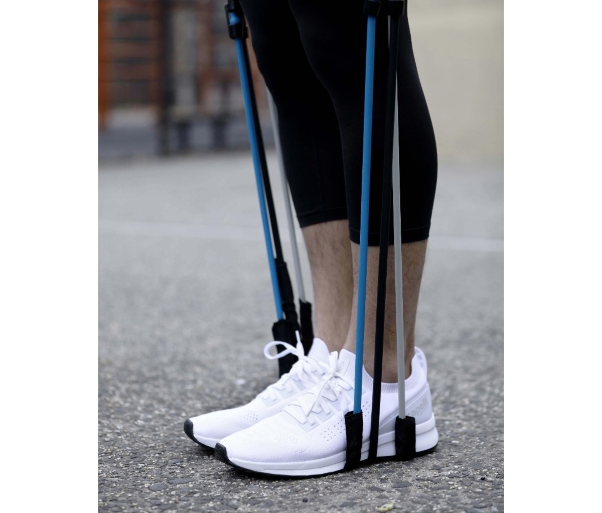 Man wearing white shoes standing on resistance bands