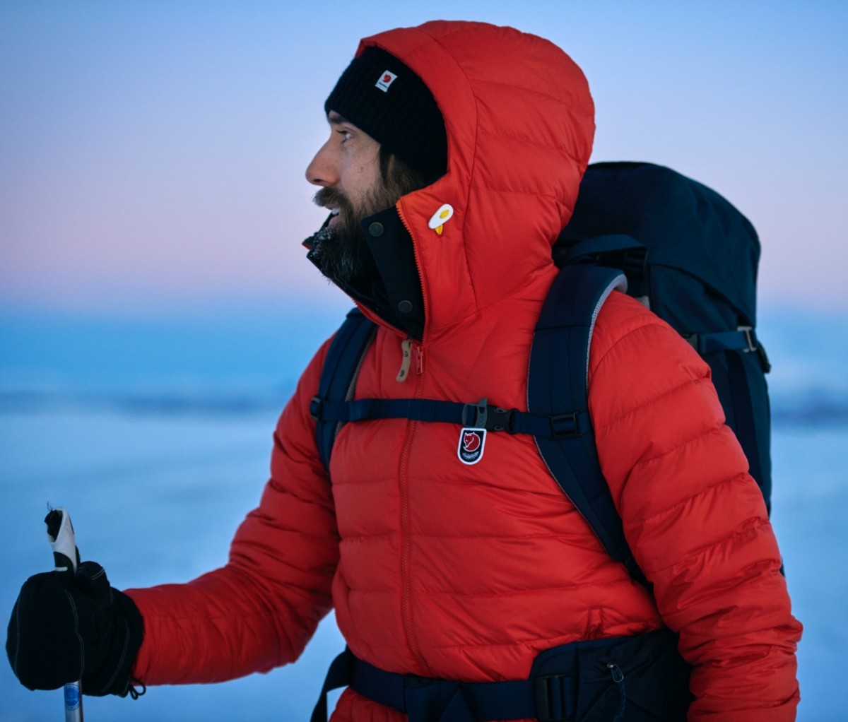 Man wearing a red Expedition Pack Down Hoodie