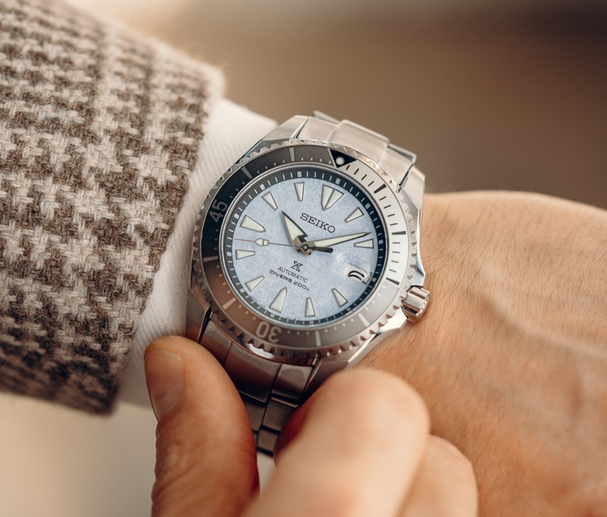 Close-up overhead shot of caucasian man's wrist with silver watch with light blue face
