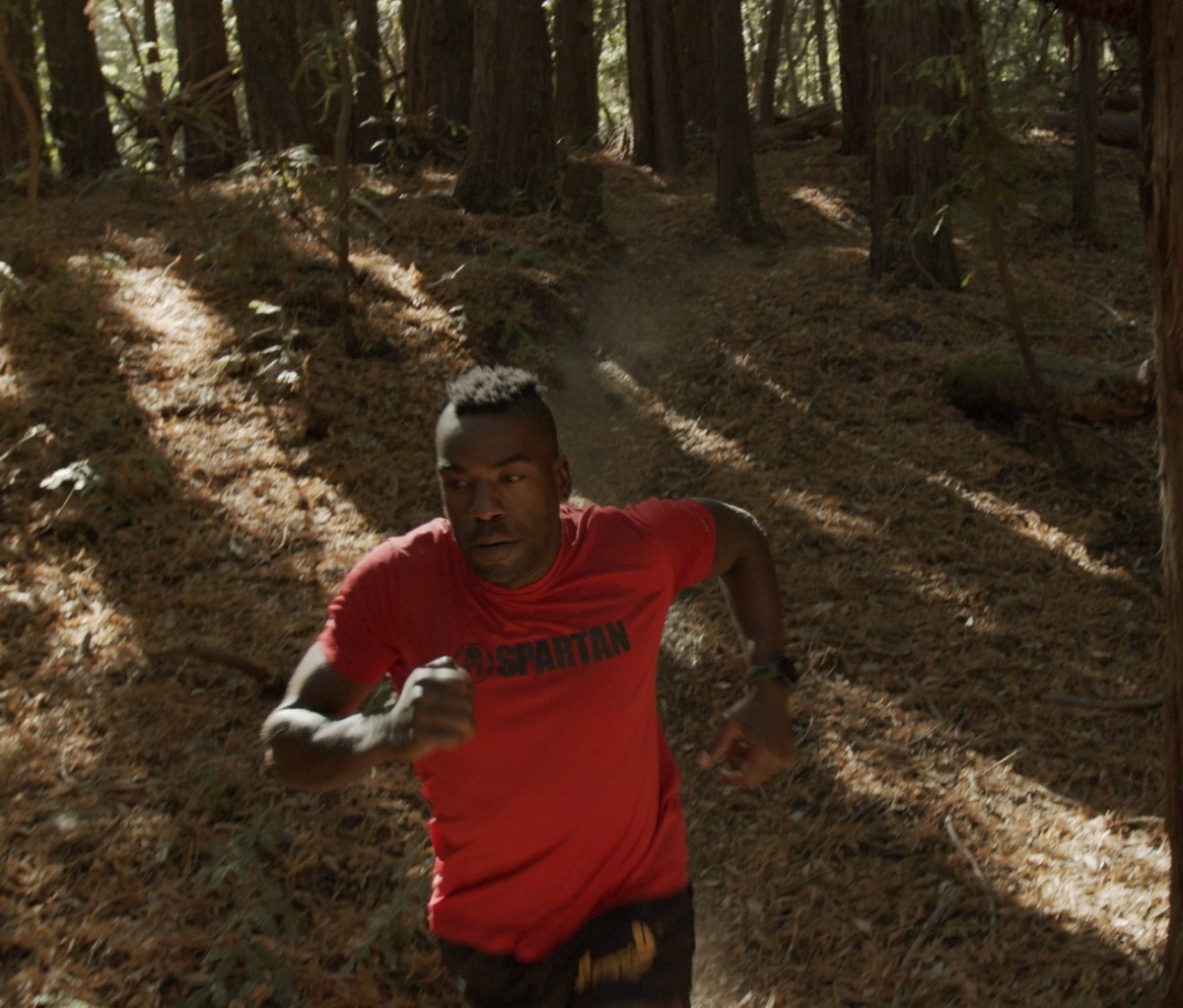 Triathlete Max Fennell running through a wooded area in California