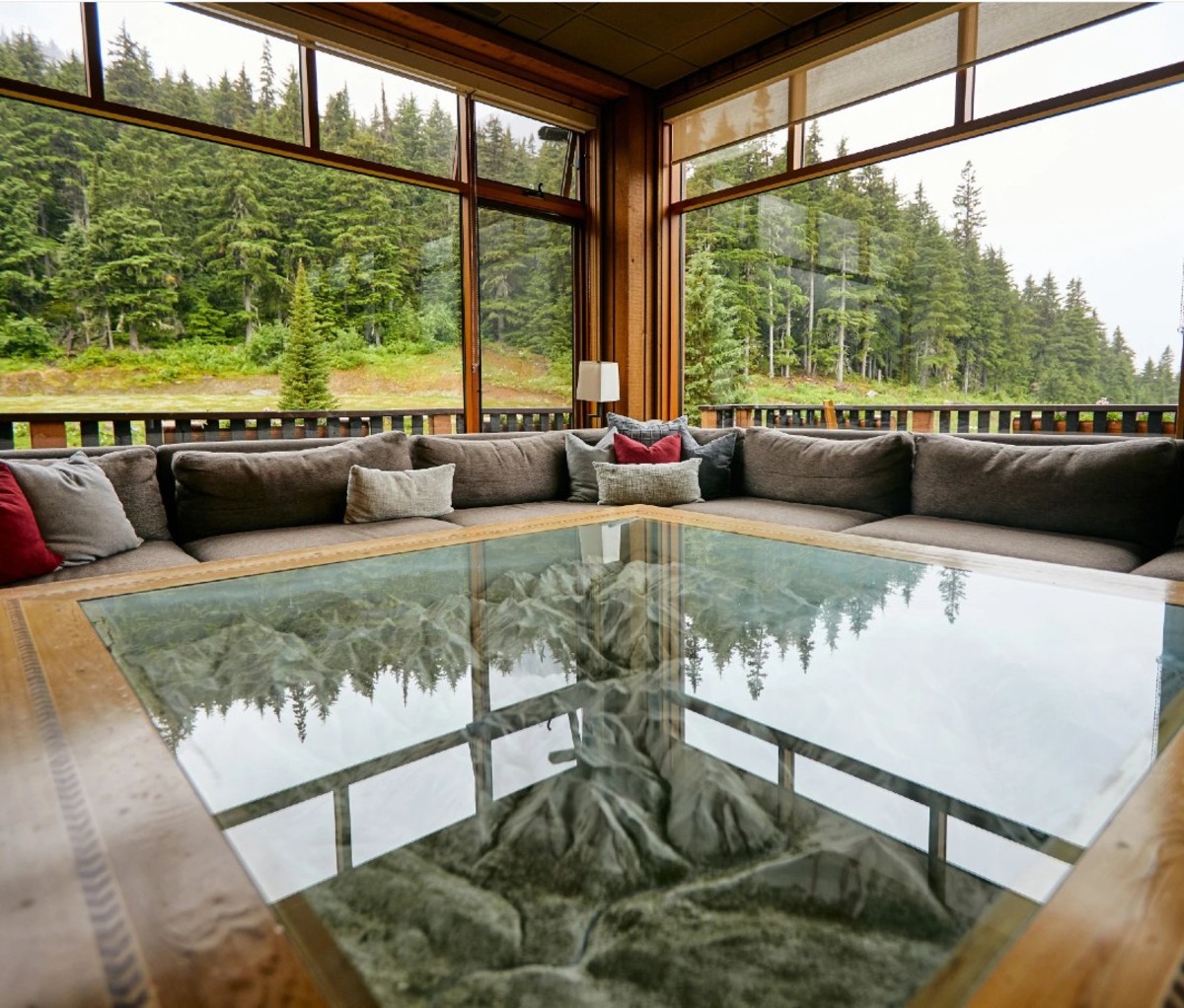 Glass table reflecting trees outside in forested area