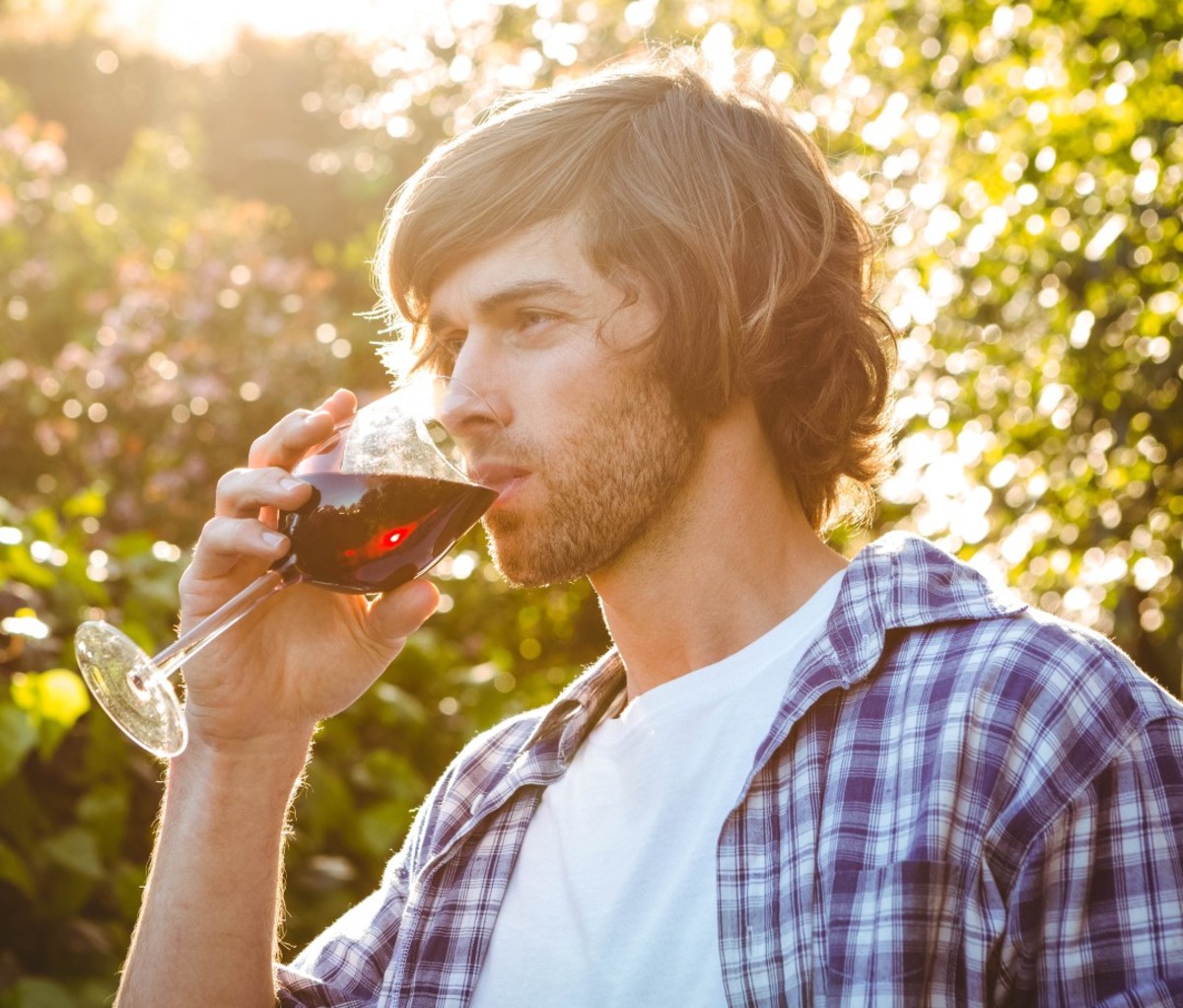 Man drinking a glass of wine.