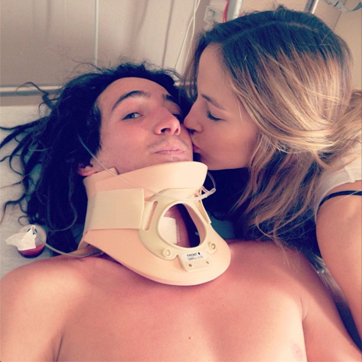 Luke Mitrani recovering in the hospital receives a kiss from girlfriend and fellow snowboarder Nadja Purtschert. Photo taken from instagram.
