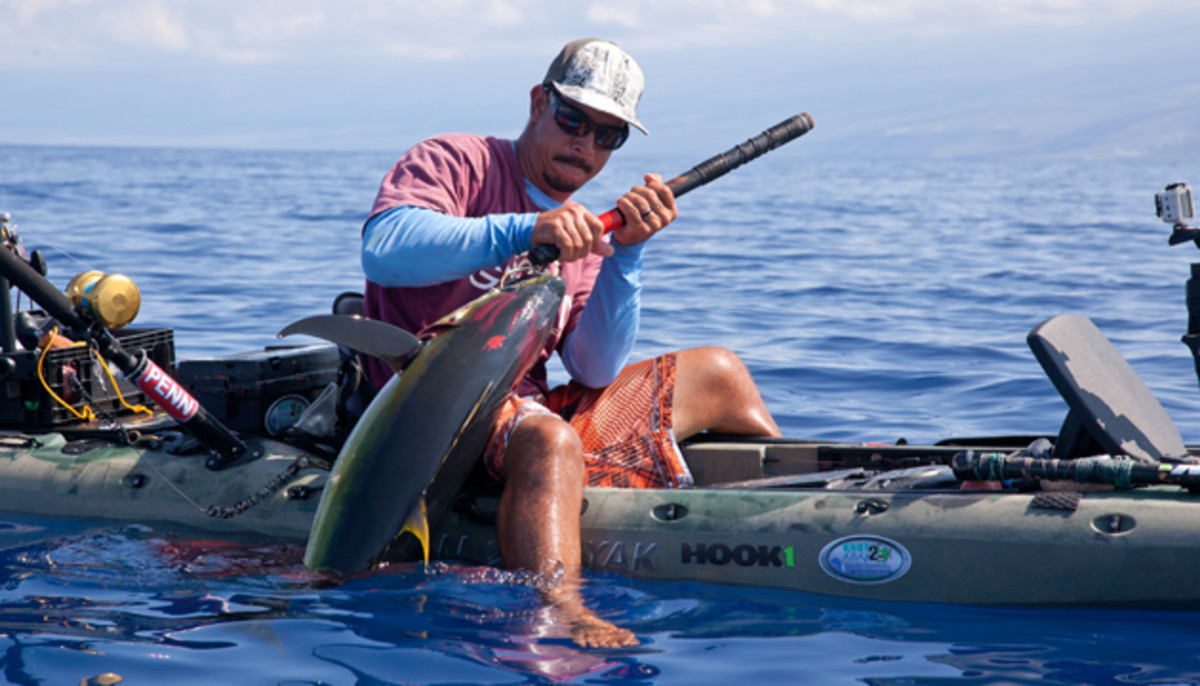 Rob Wong Yuen dangles his feet in a puddle of blood while landing a shibi off the Big Island this summer.