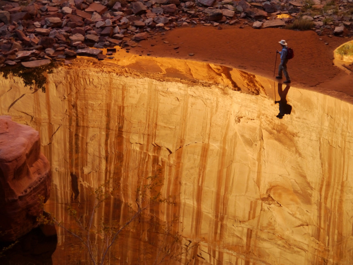 Optical illusion seems to show a hiker walking on the edge of a sheer cliff
